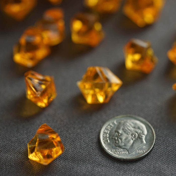 Yellow crystal-shaped gems scattered next to a coin.