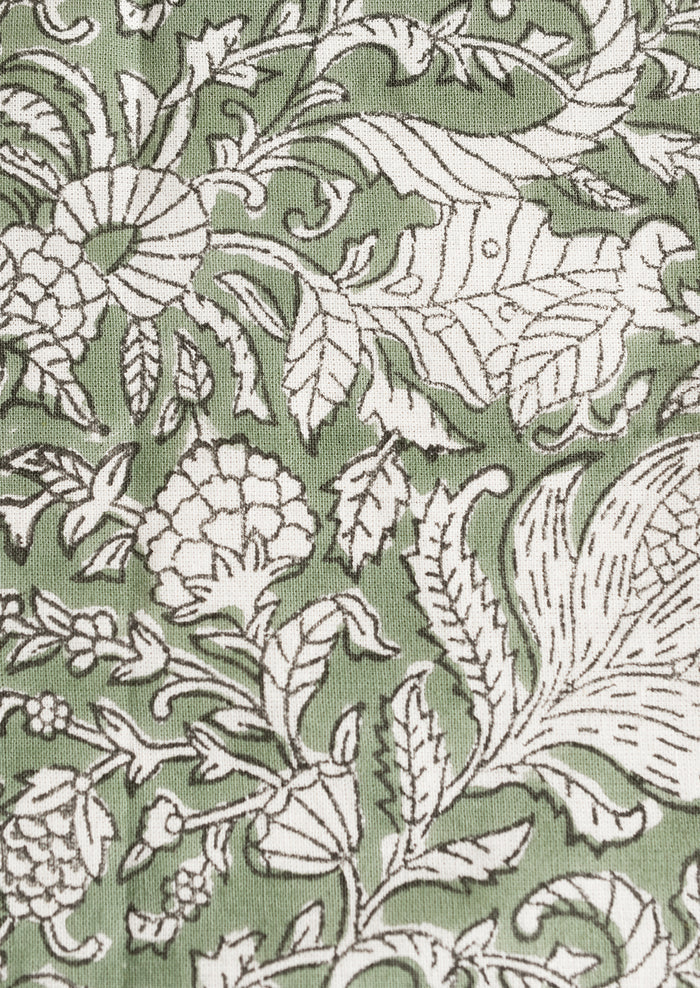A pair of block print napkins in ivy green with black and white floral print.