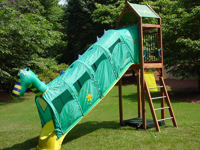 Draco Fantaslide Slide Attachment on wooden playset slide, green dragon-themed tunnel with mesh windows and star accents