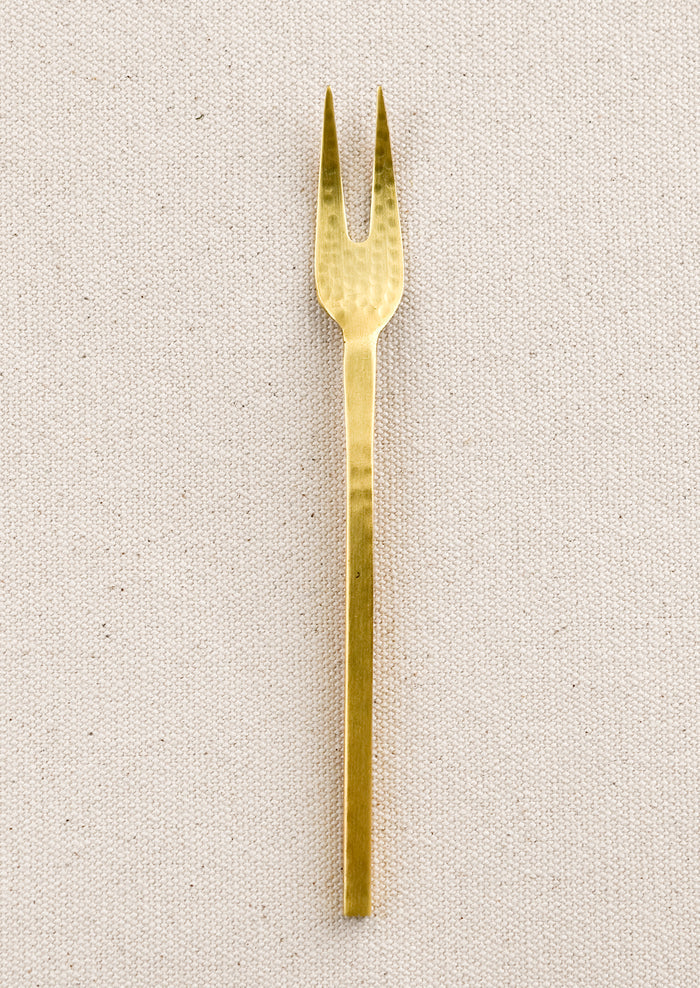 A small canape fork in hammered gold finish.