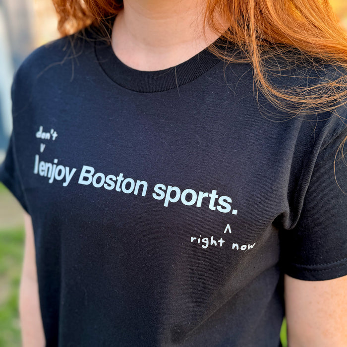 woman wearing I don't enjoy Boston sports right now. t-shirt, black unisex tee with handwritten annotation over original design