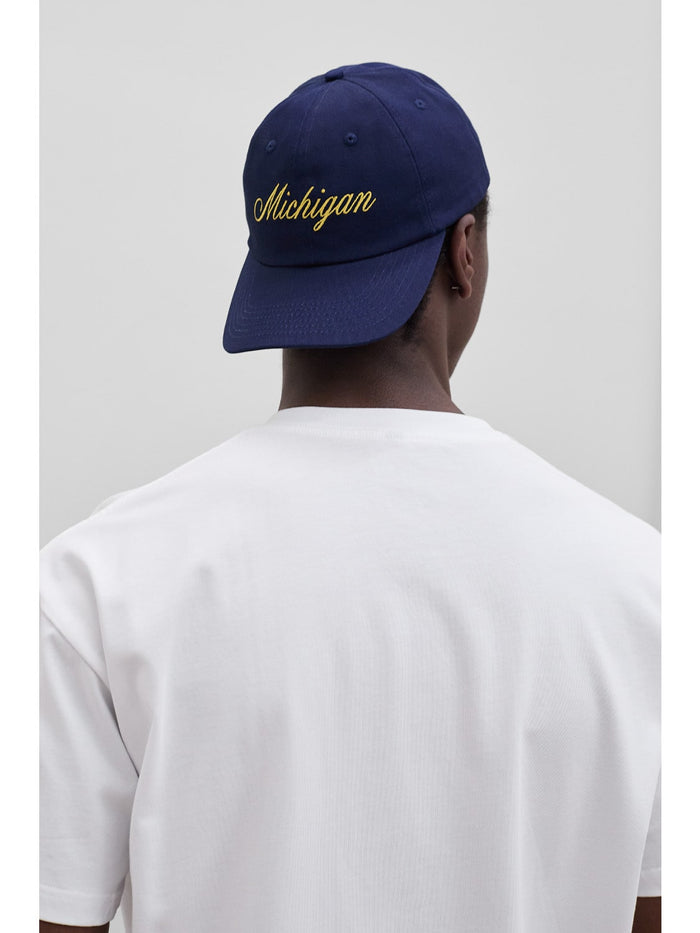 model wears michigan script hat backwards one dna