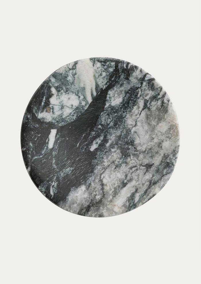 A round soap dish made of variegated black marble.