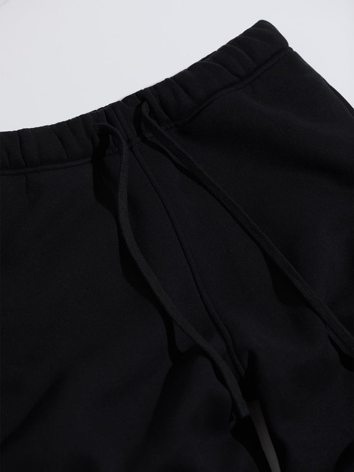 Detail of ONE DNA black sweatpants with black drawstring on a gray background