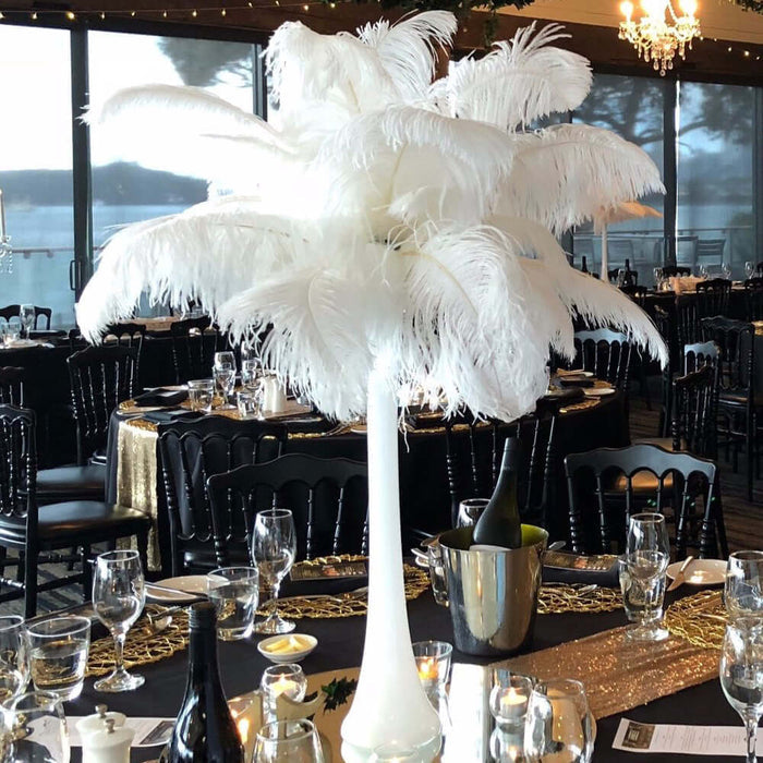 White feather centerpiece on elegantly set dining table.