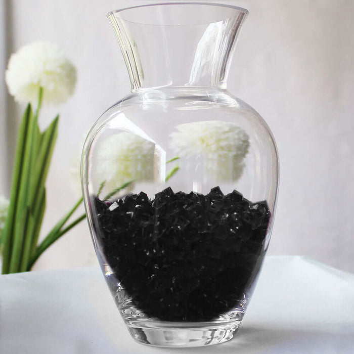 Clear glass vase filled with black decorative stones.