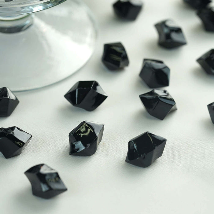 Black decorative resin pieces scattered on a light surface.