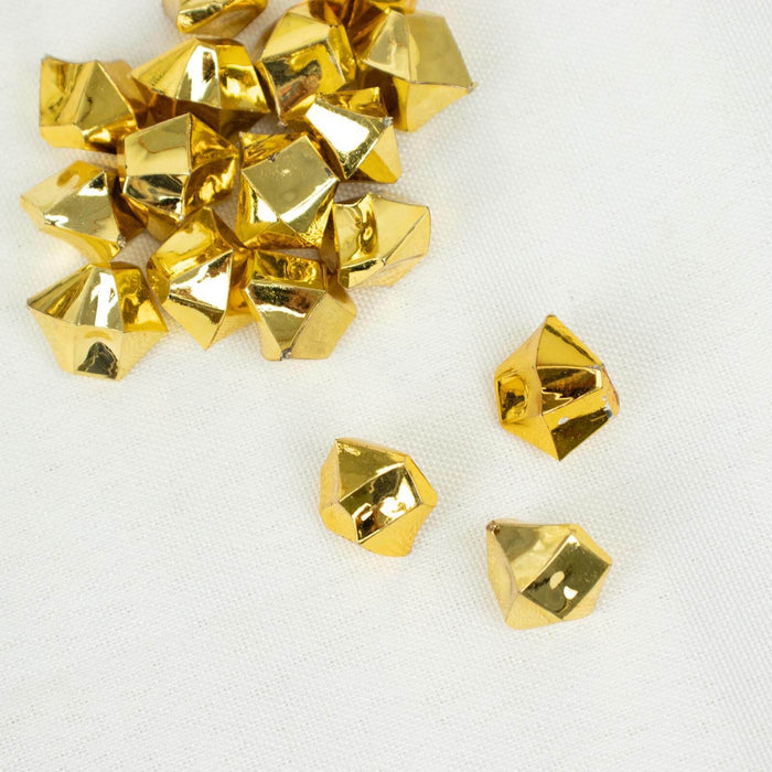 Gold geometric decorative beads on a light fabric background.