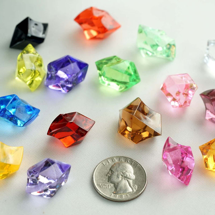 Colorful acrylic gemstones with a quarter for scale on a white background.