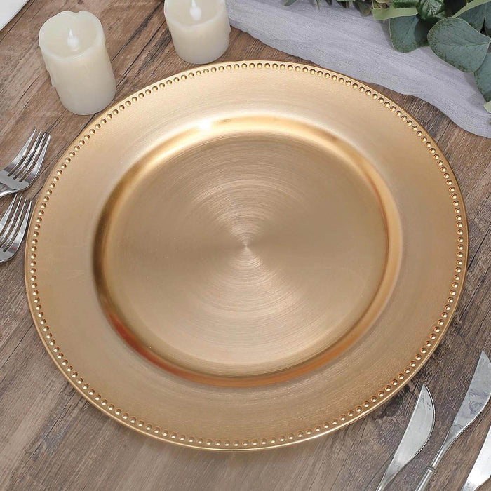 Gold charger plate with beaded edge on rustic wooden table.