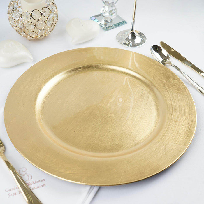Gold charger plate on a white table setting with elegant decor.