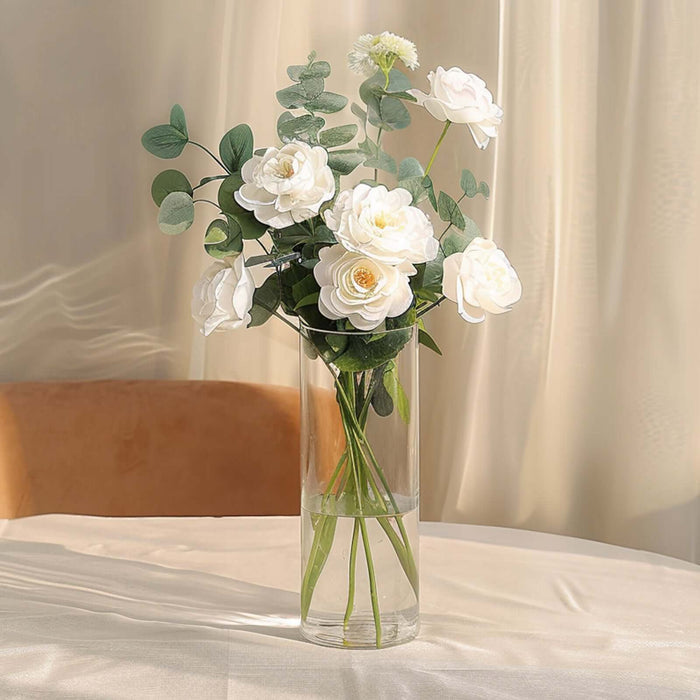 White floral arrangement in a glass vase on a table.