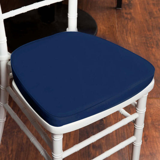 Navy blue chair cushion on a white chair against a wooden floor
