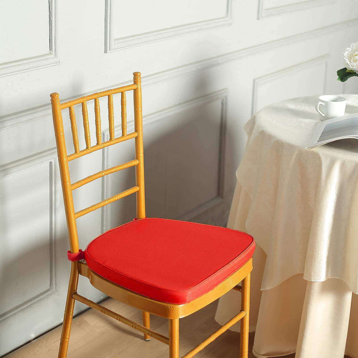 Red chair cushion on a wooden chair beside a table in a stylish setting.
