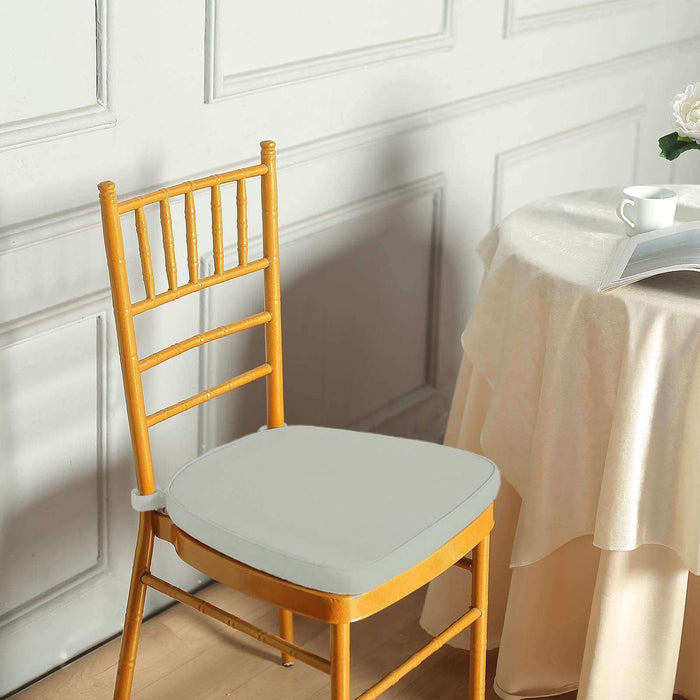 Gold chiavari chair with gray cushion in elegant indoor setting.