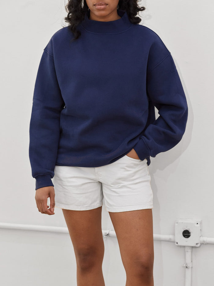 female model wears navy mockneck sweatshirt one dna