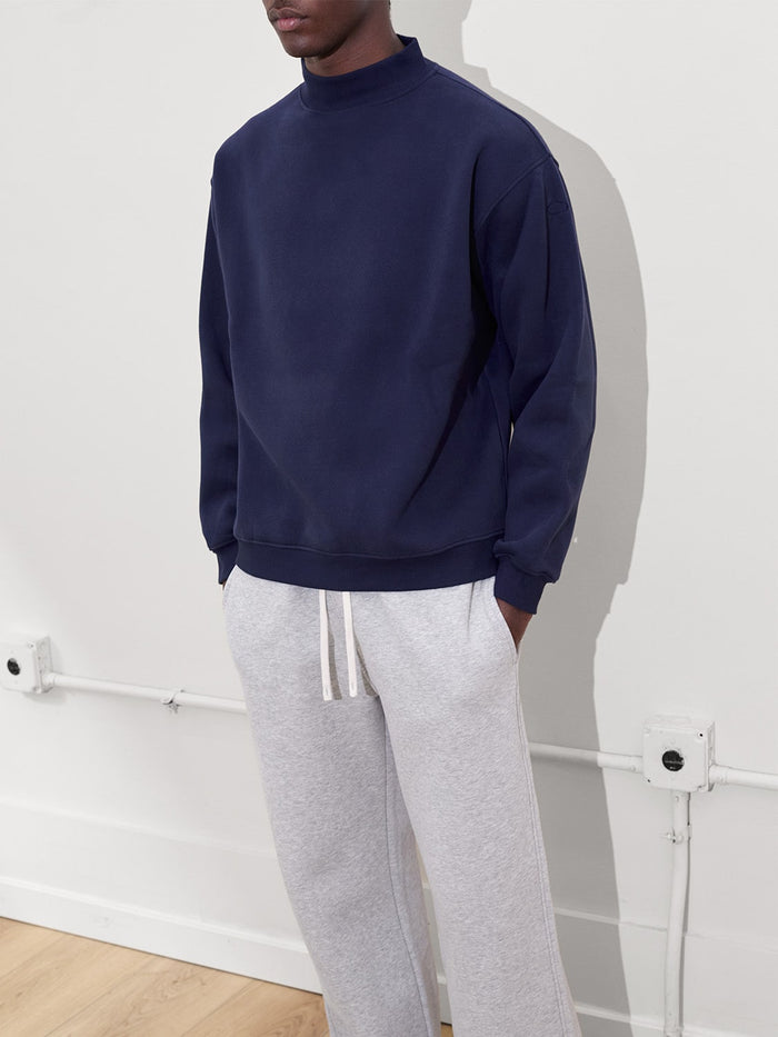 male model wears mock neck sweatshirt in navy one dna clothing
