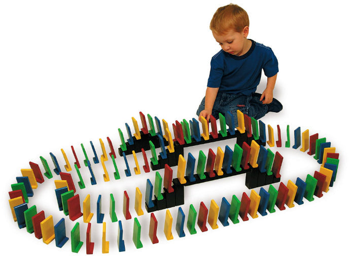 Easy Stand Domino Set with colorful, extra large dominoes and bridges arranged in a pattern around a child playing on the floor