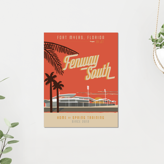 11x14 Fenway South art print with red background and jetblue park with palm trees. Mounted on a grey wall with plants nearby