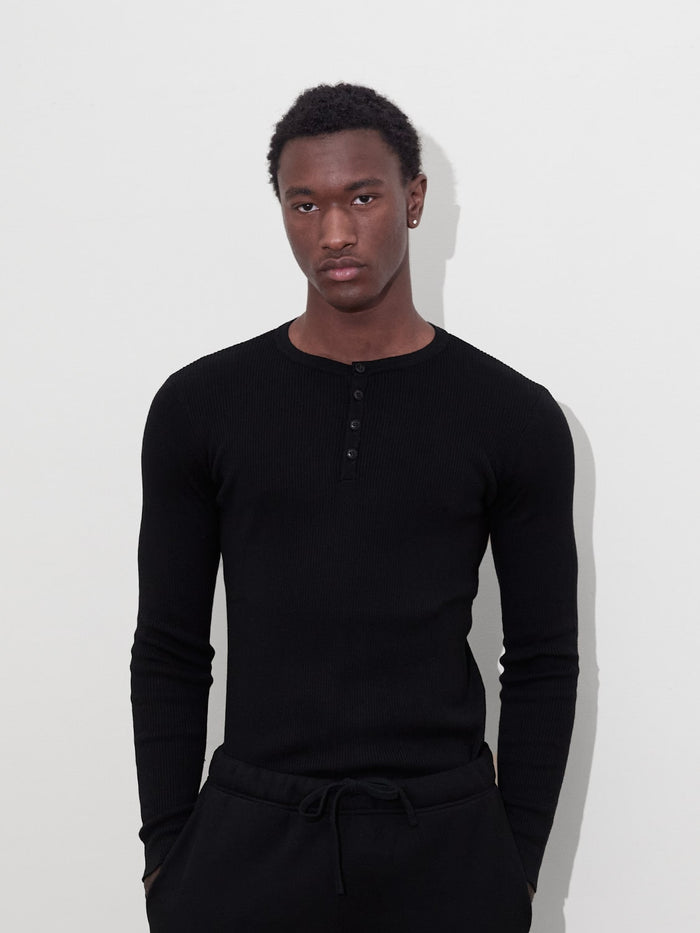 male model on white background wears black rib knit henley one dna