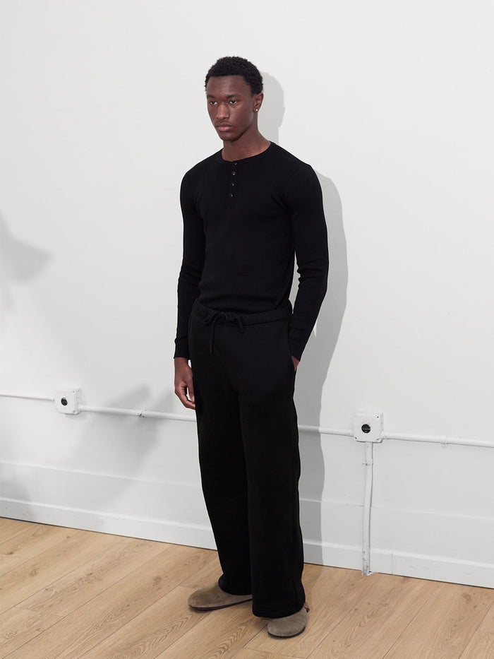 male model wears black rib knit henley one dna clothing