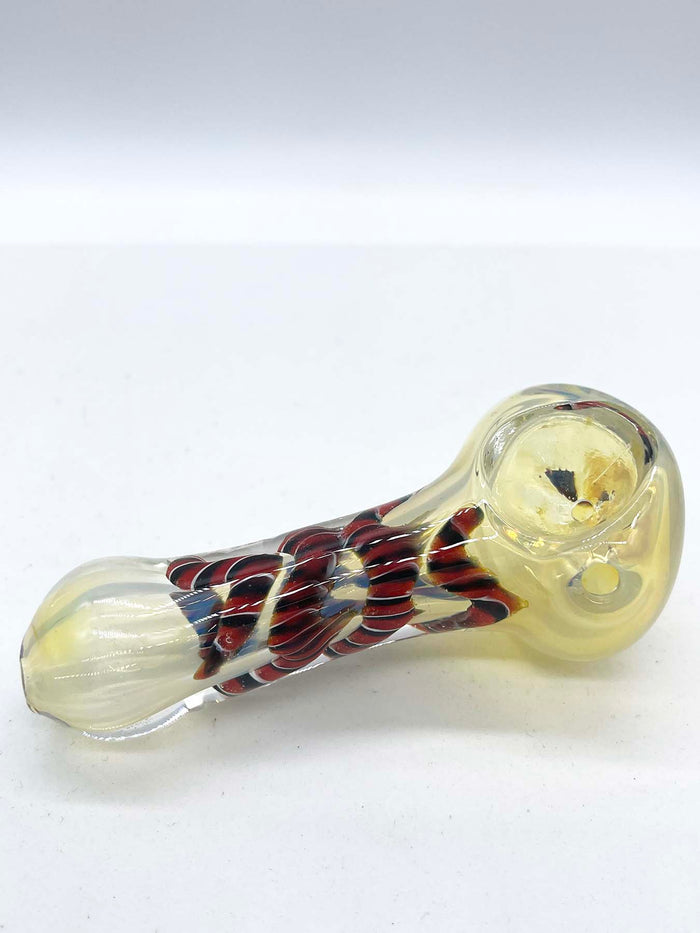 Photo of a glass spoon against a white background. The piece has a round bowl and a long body that is thinner in the middle. The piece has a milky sheen to it, and there is red ribbon coiled in the middle.