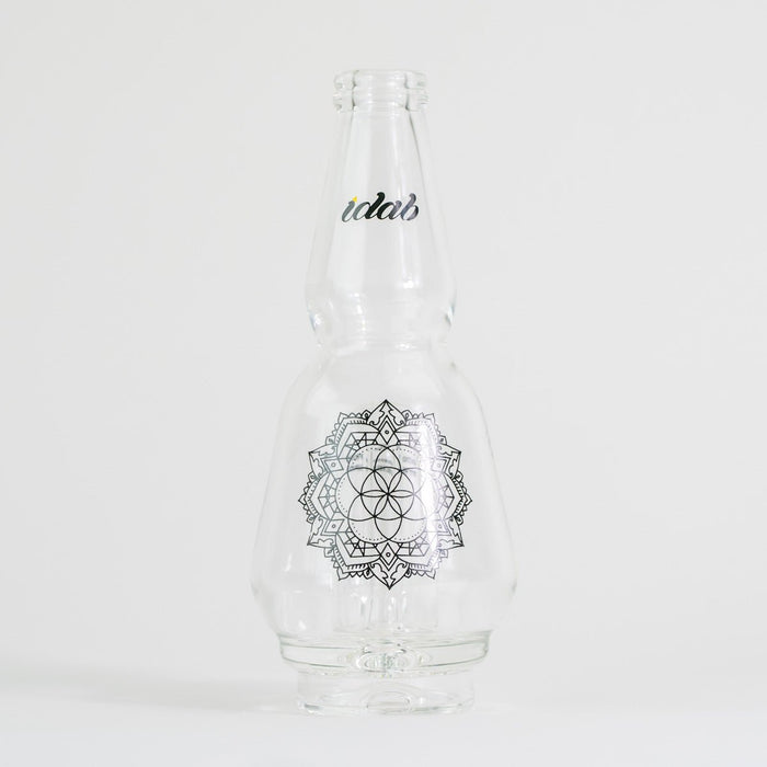 Clear glass bottle with floral design and text on white background