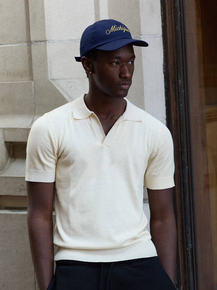 a male model wears a michigan script hat and polo by one dna ann arbor