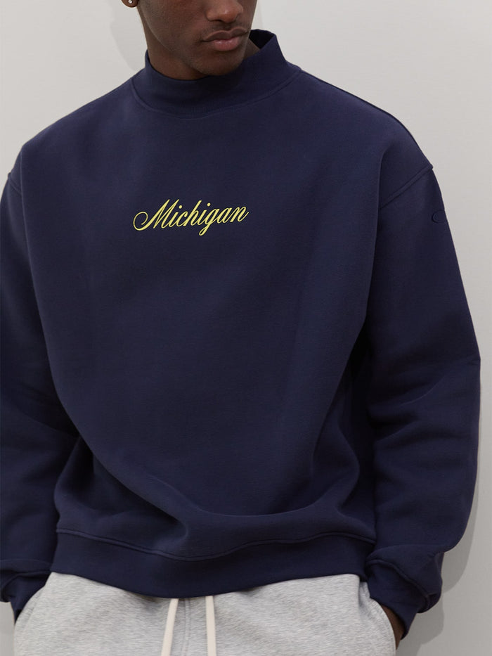 male model wears michigan script mock neck sweatshirt in navy one dna