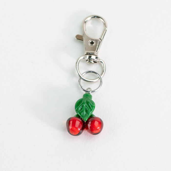 Glass Puffco keychain with cherry design on a white background