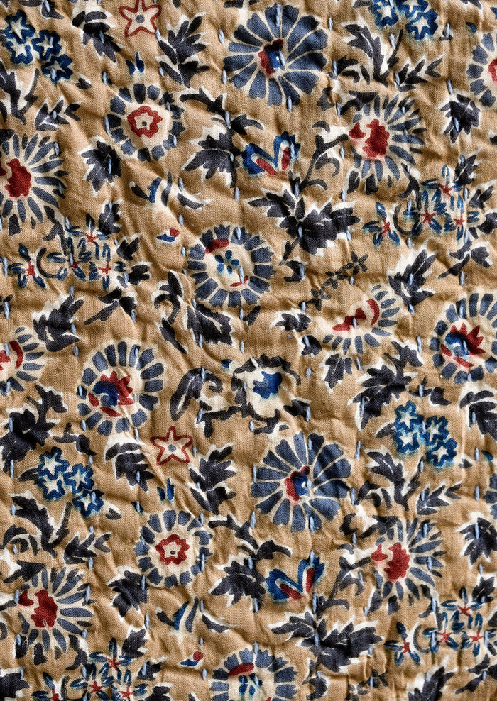 A kantha stitched throw blanket with blue and brown floral print.