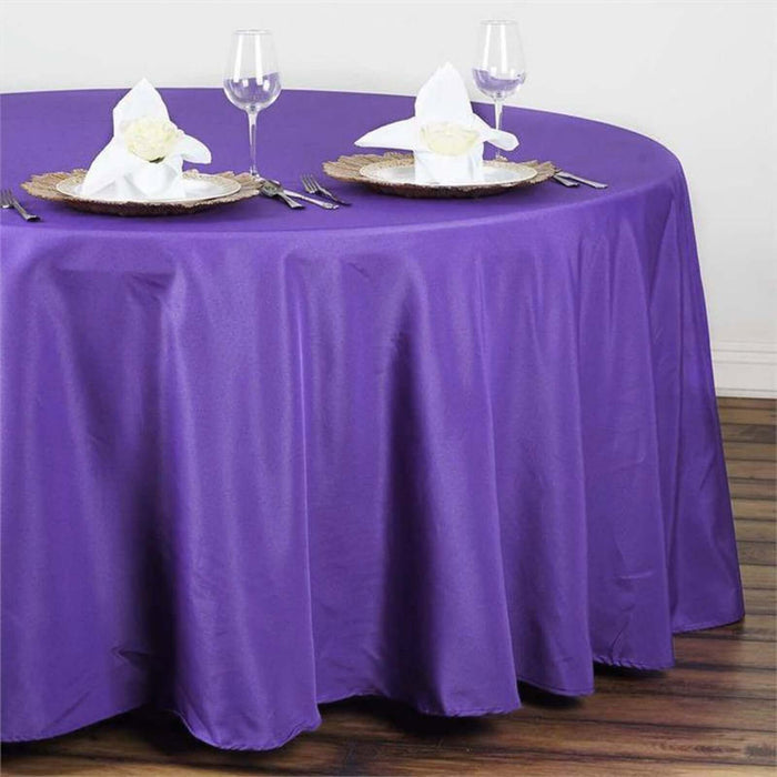 Purple round tablecloth draped elegantly over a table set for dining.