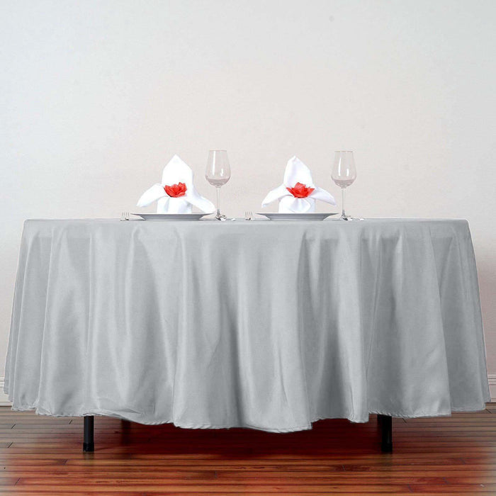 Elegant gray tablecloth draped over a table set for two with decorative napkins.