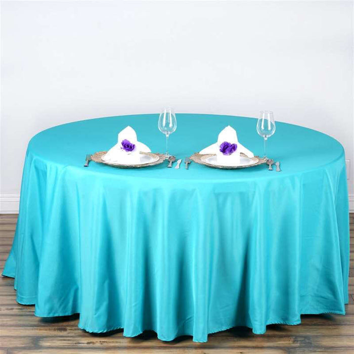 Round turquoise tablecloth with elegant table setting for two.