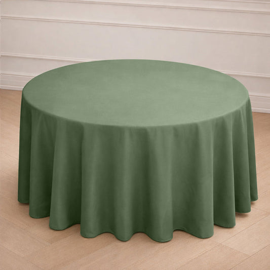Round green tablecloth draped over a circular table in a simple setting.
