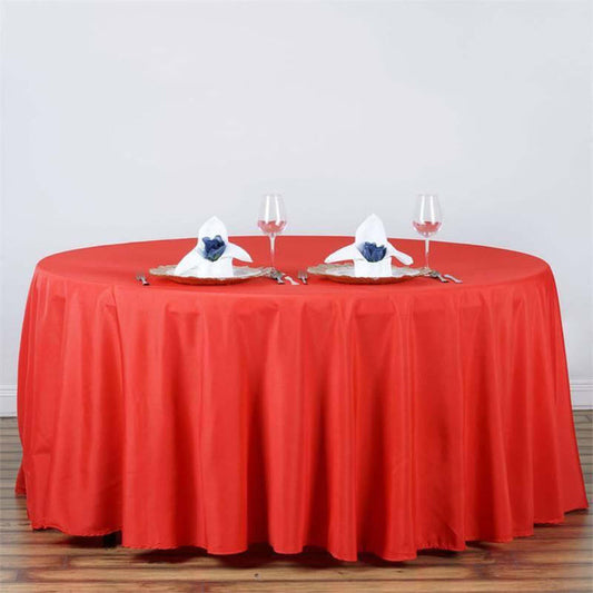 Red round tablecloth with elegant table setting for two.