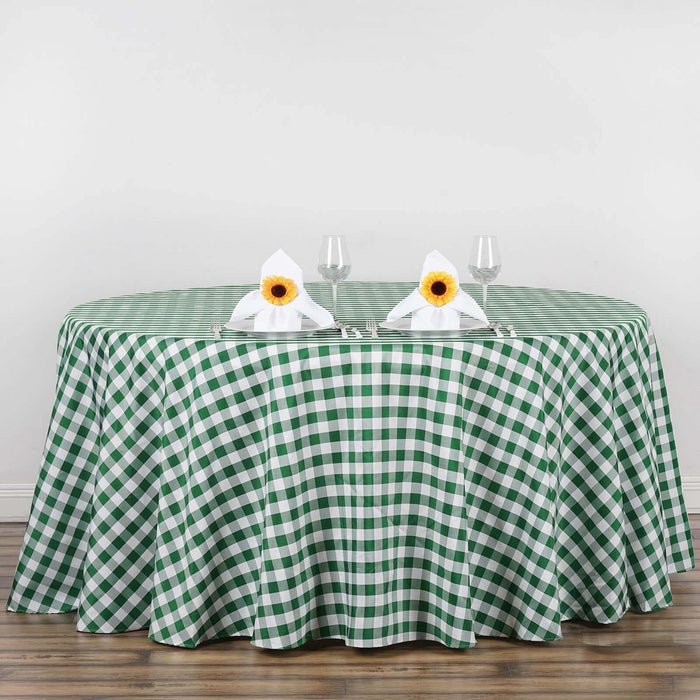 Green and white checkered tablecloth on a round table with floral napkin decor.