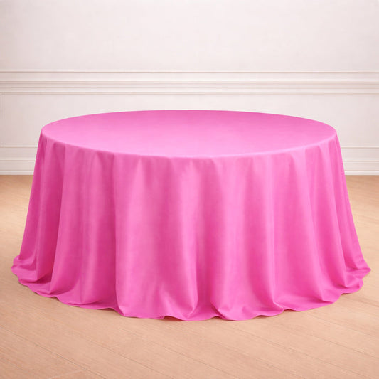 Round pink tablecloth on a wooden floor.