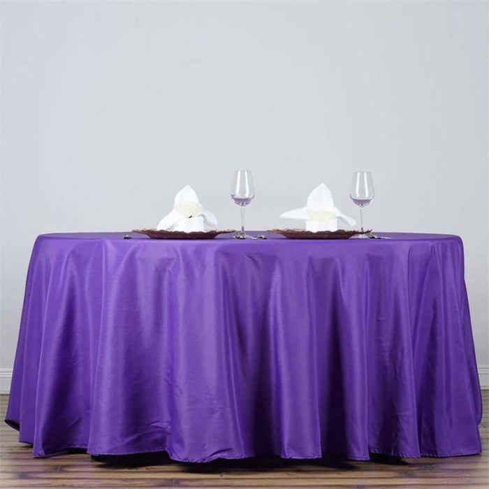 Purple tablecloth draped elegantly on a table with decorative napkins and glasses.