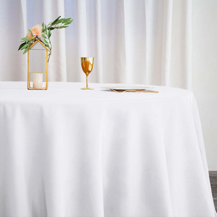 Elegant table setting with a gold glass, candle holder, and floral decor.