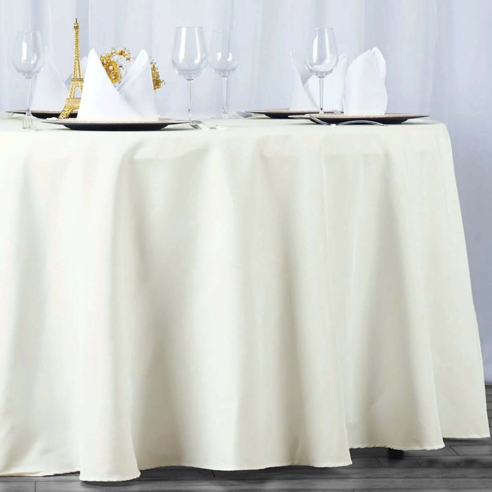 Elegant cream tablecloth draping a dining table set with wine glasses and napkins.