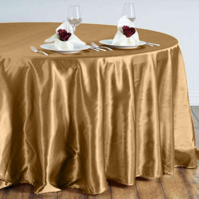 Elegant gold tablecloth draped over a round table set for dining.