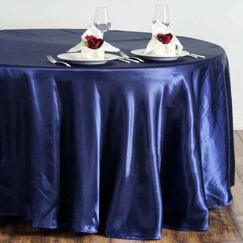 Navy blue satin tablecloth elegantly draped on a table with plates and napkins.