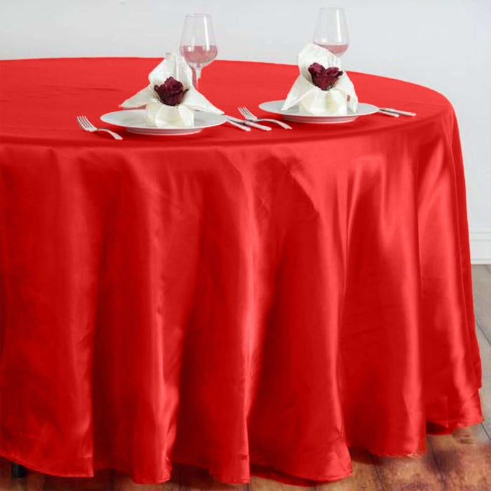 Red tablecloth draped elegantly over a round table set for dinner.