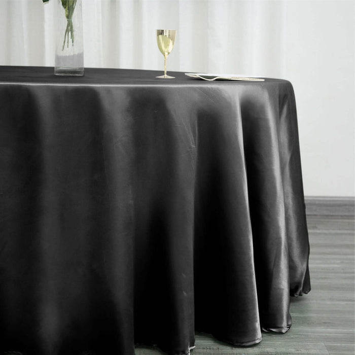 Elegant black tablecloth draping over a table, styled with a glass and plate.