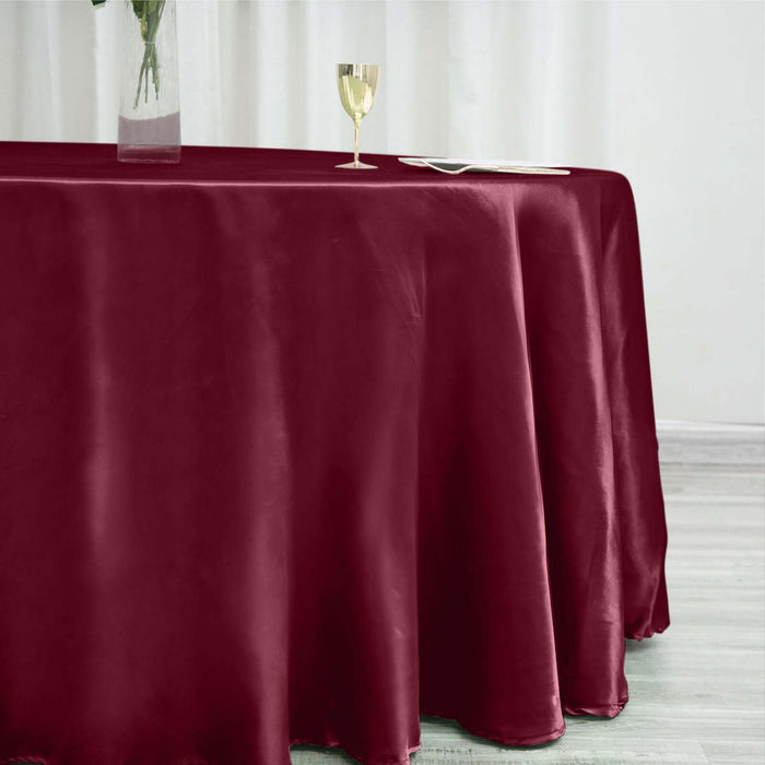 Burgundy tablecloth draped elegantly on a table with a glass and plate.