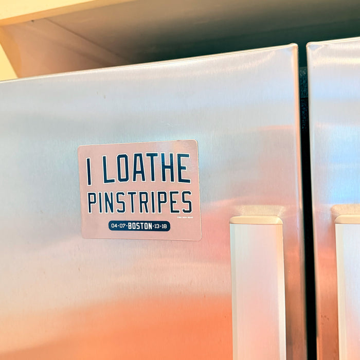 Refrigerator magnet with text 'I LOATHE PINSTRIPES' on a stainless steel fridge