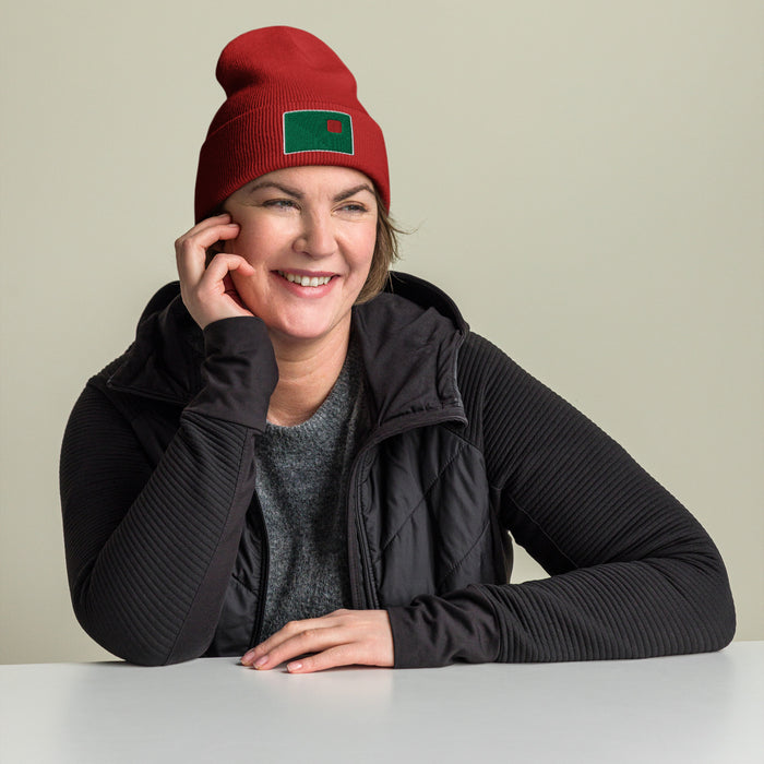 photo of a woman wearing red beanie with the red seat logo in green and red embroidered on the cuff