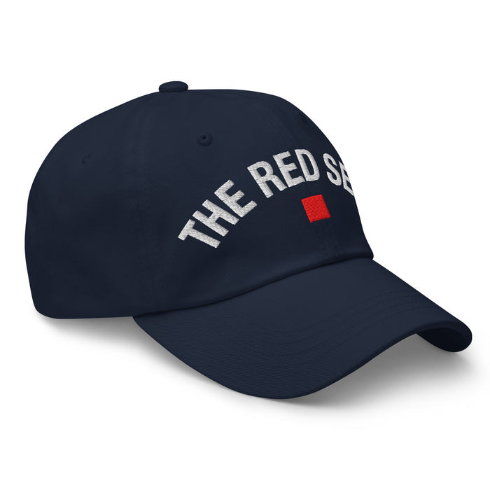 side view of navy dad cap with “The Red Seat” embroidered in white and red icon