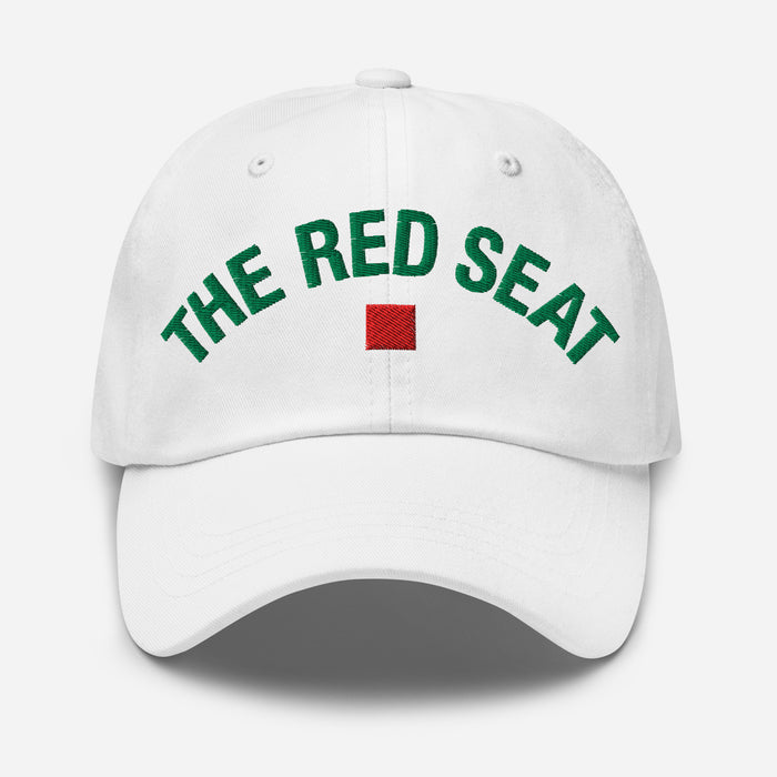 White cap with 'The Red Seat' text in green and a red square logo on a white background